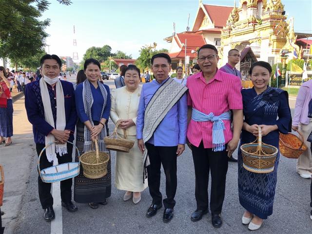 พช.นครพนม ร่วมใจพร้อมครอบครัวหิ้วตะกร้า ศรัทธาอิ่มบุญ อุดหนุนชุมชน : สวมผ้าไทย ห่มสไบ ใส่บาตรริมโขง