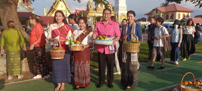 พช.นครพนม ร่วมใจพร้อมครอบครัวหิ้วตะกร้า ศรัทธาอิ่มบุญ อุดหนุนชุมชน : สวมผ้าไทย ห่มสไบ ใส่บาตรริมโขง