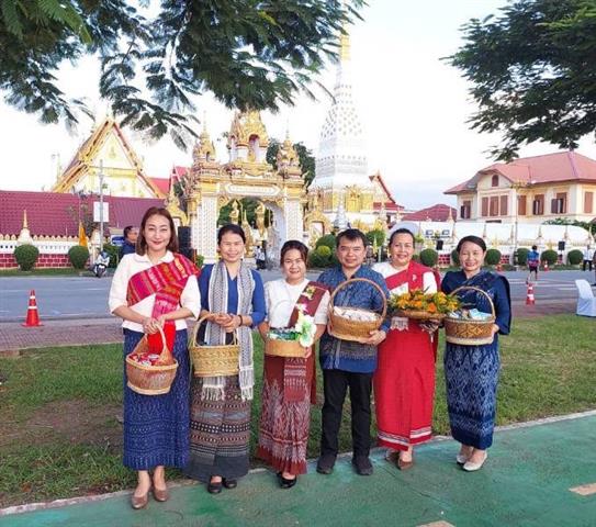 พช.นครพนม ร่วมใจพร้อมครอบครัวหิ้วตะกร้า ศรัทธาอิ่มบุญ อุดหนุนชุมชน : สวมผ้าไทย ห่มสไบ ใส่บาตรริมโขง